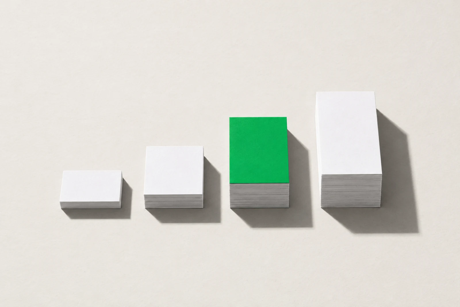 Quatre piles de cartes blanches en escalier, de la plus basse à la plus haute, avec une seule carte verte posée sur la troisième pile.