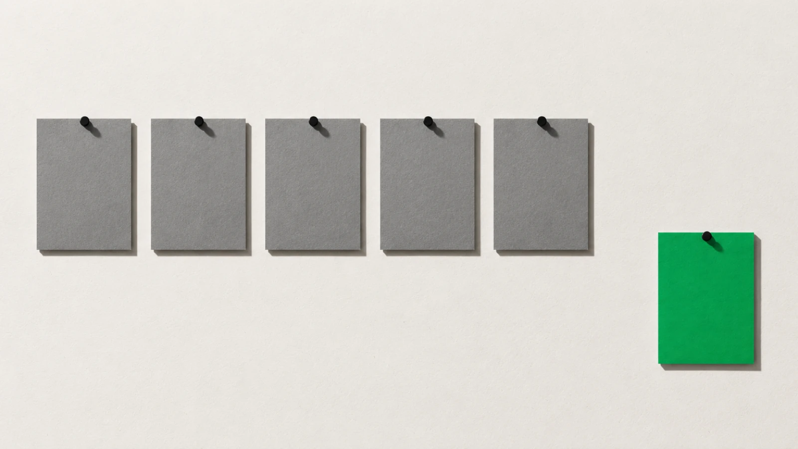 Cinq rectangles de carton gris punaisés en rangée sur un papier crème, et un sixième rectangle vert punaisé à l'écart, plus bas sur la droite.