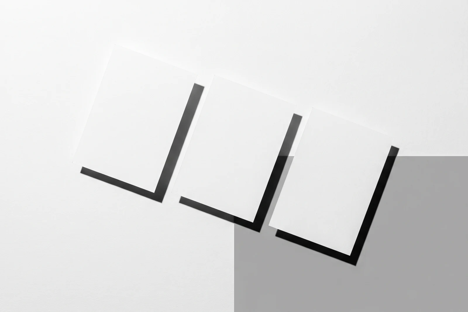 Une rangée de cartes de papier qui dérive progressivement hors de l’axe, ombres dures projetées vers le bas à droite.