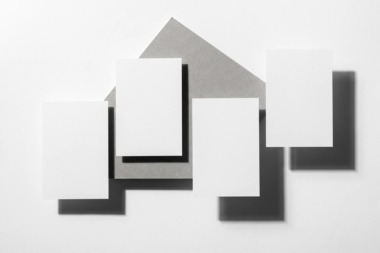 Une rangée de cartes de papier qui dérive progressivement hors de l’axe, ombres dures projetées vers le bas à droite.